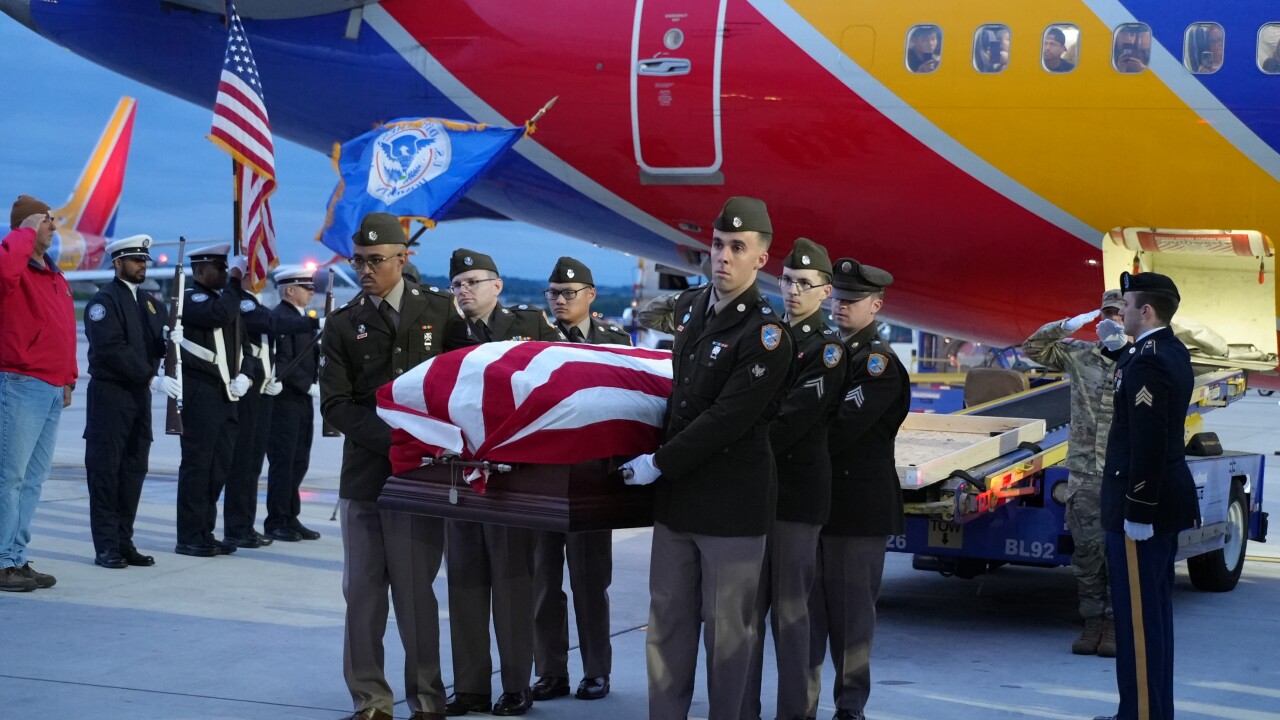 The Army Honor Guard carries Private Heigh's remains off of Southwest Flight 2415