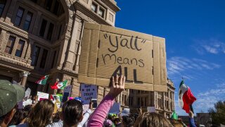 A person holds a sign during an immigration protest