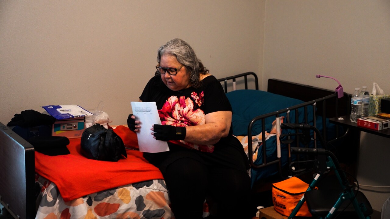 Mary sits on her hospice bed with her petition
