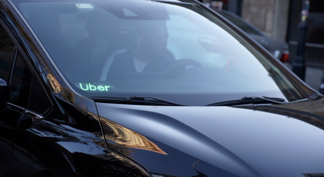 A car with the Uber logo in the corner of the window