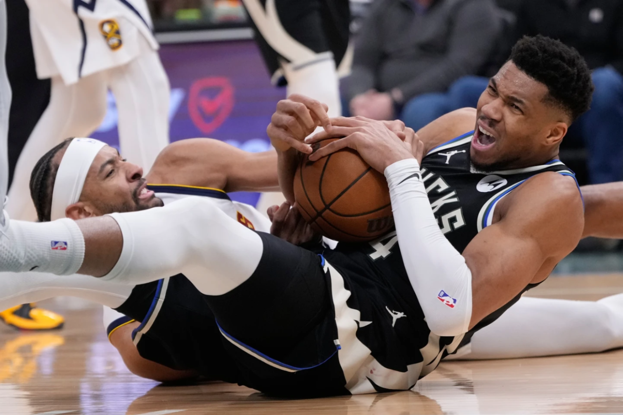 Milwaukee Bucks' Giannis Antetokounmpo, right, and Denver Nuggets' Zeke Nnaji battle for a loose ball during the second half of an NBA basketball game Friday, Jan. 23, 2026, in Milwaukee.