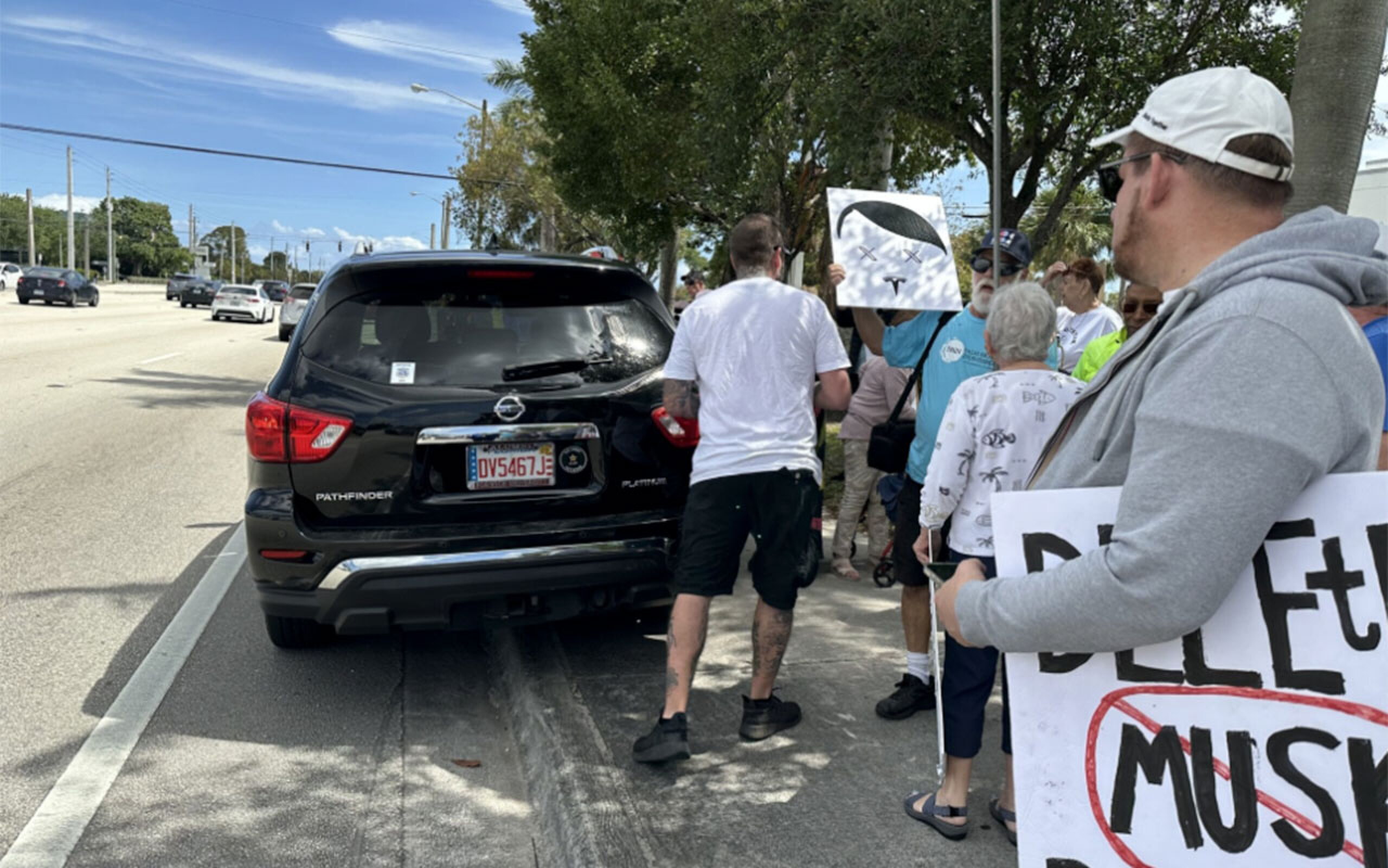 Man arrested for driving into protesters at Tesla dealership