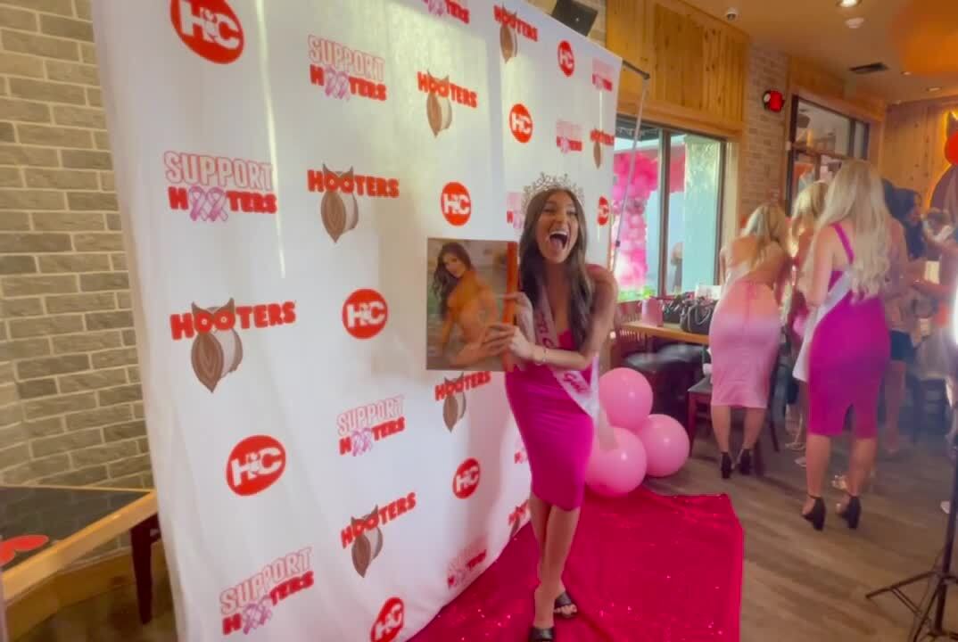Gianna Tulio all smiles as she holds 2022 Hooters calendar on which she graces cover, Oct. 1, 2021