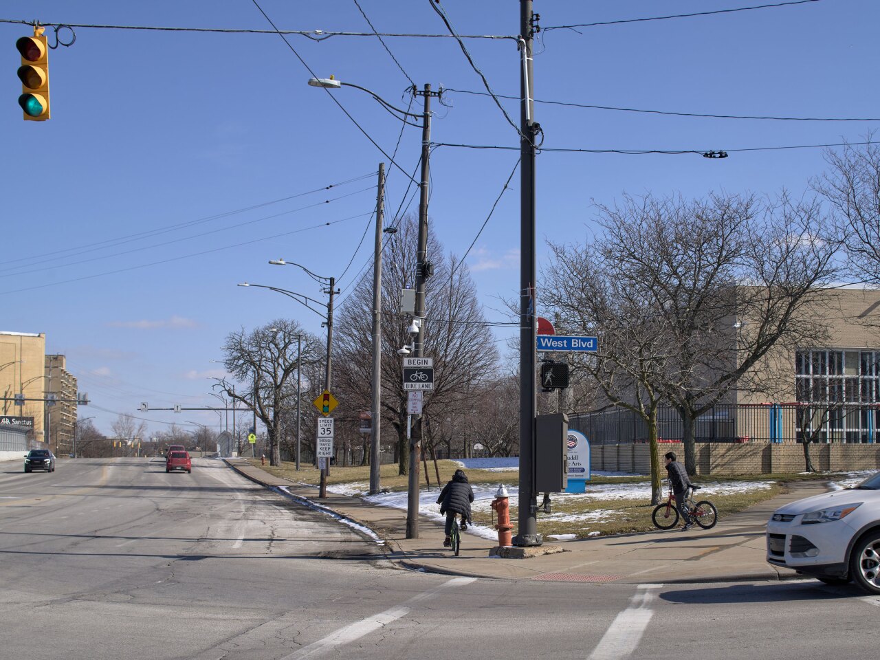 A photograph of two children riding bikes past surveillance cameras mounted near a recreation center.