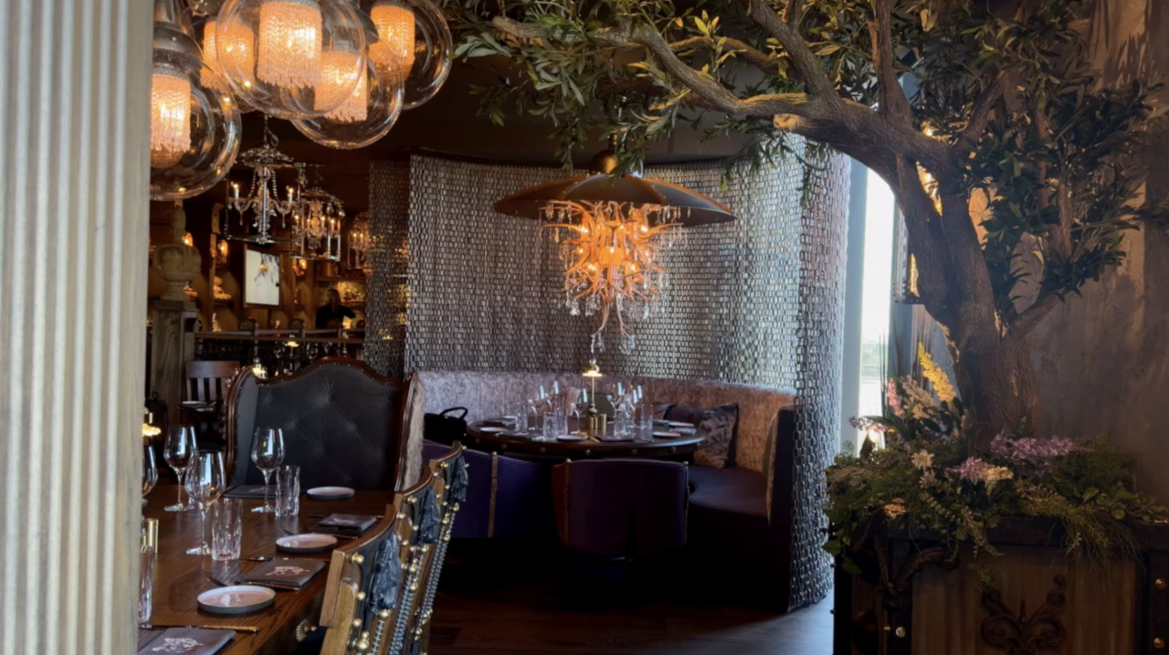 Earthy tones and crystal chandeliers enhance the ambiance of the wolf-themed restaurant, contributing to its vibe.