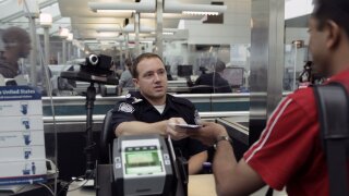 U.S. Customs and Border Protection officer checks a passport