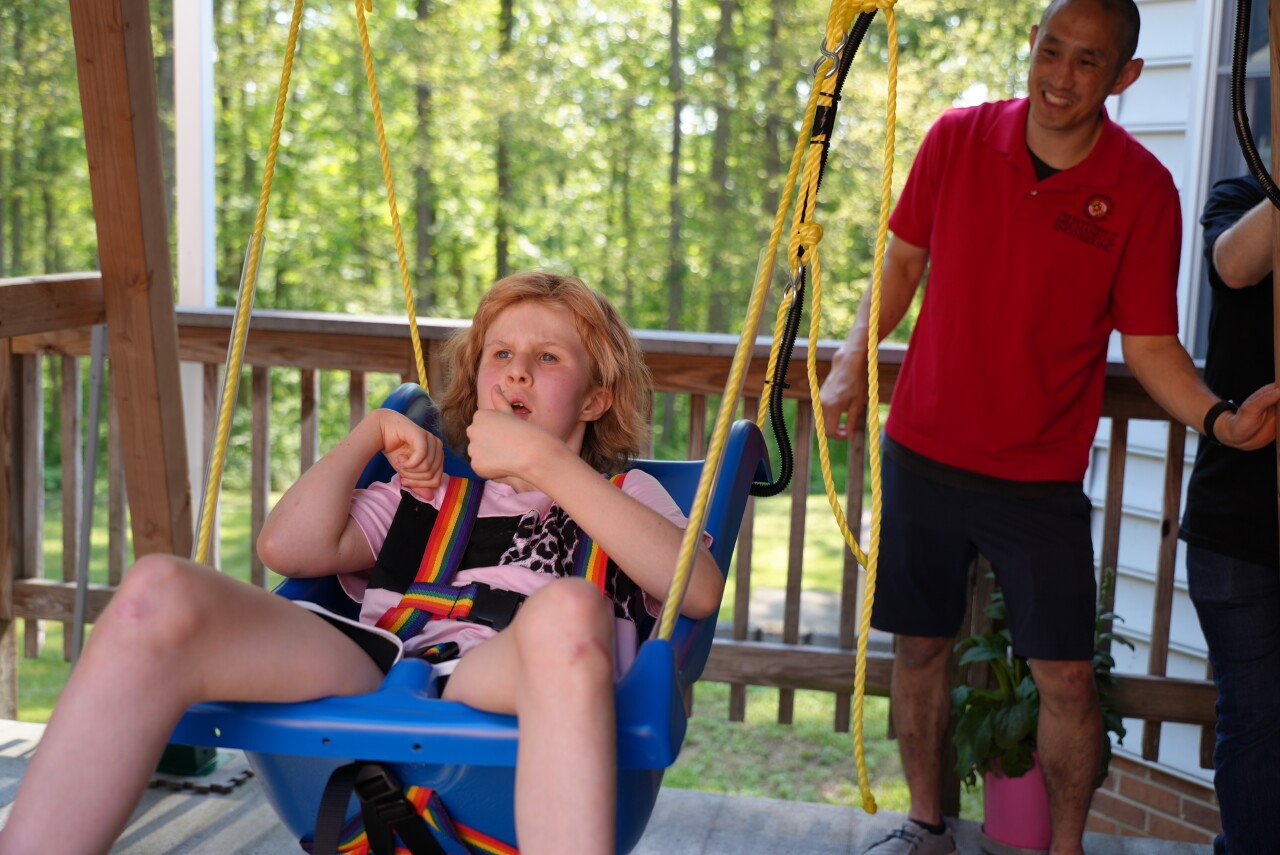 Avaleigh giving a thumbs up from her swing