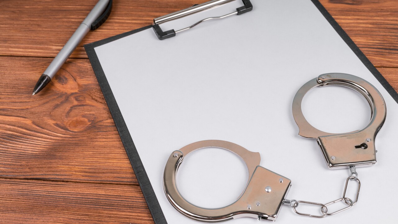 Handcuffs,On,A,Tablet,With,A,Blank,Sheet,Of,Paper.