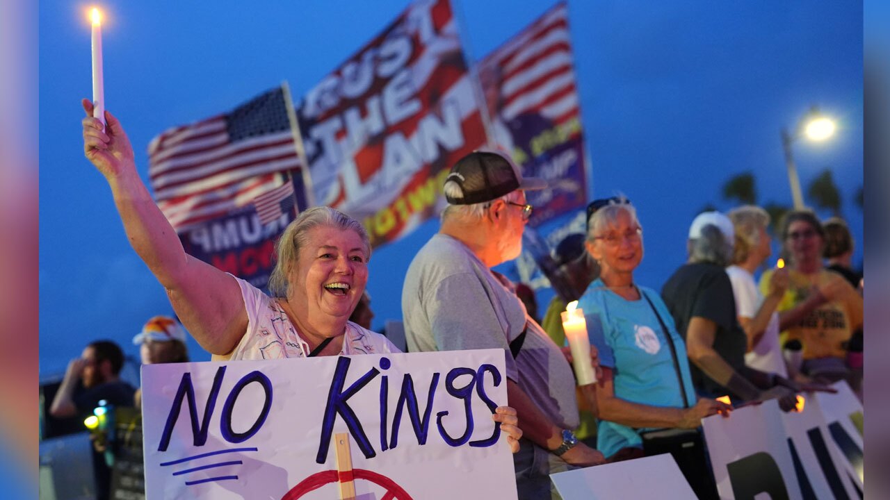 Dee Cahill of Margate, Fla., holds a "No Kings" sign as she participates in a pro-democracy, anti-Trump protest outside Trump's Mar-a-Lago estate in Palm Beach, Fla., as part of the "Good Trouble Lives On" national day of action, Thursday, July 17, 2025. 