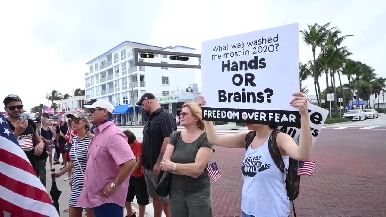 'Hands or Brains? Freedom Over Fear' sign at Delray Beach march to end mask mandate