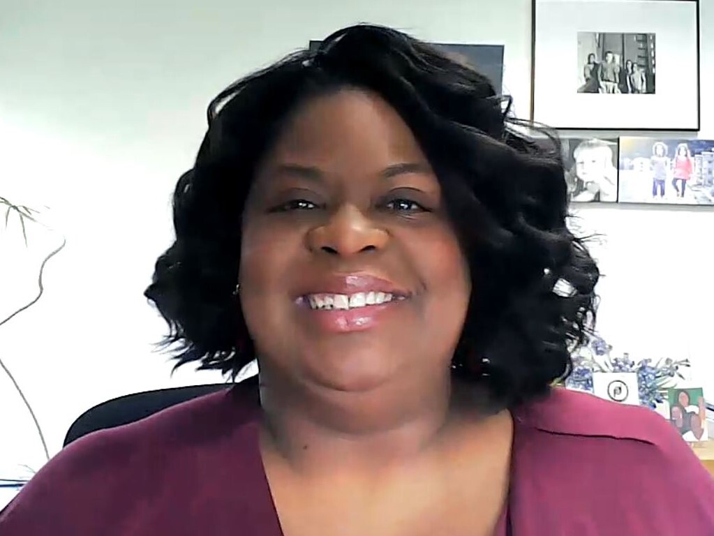 Jeniece Jones is smiling in this photo. Her wavy, black hair reaches almost to her shoulder, and she is wearing a dusty rose-colored blouse.