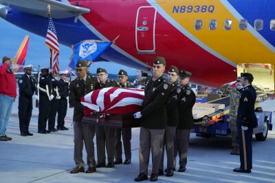 The Army Honor Guard carries Private Heigh's remains off of Southwest Flight 2415