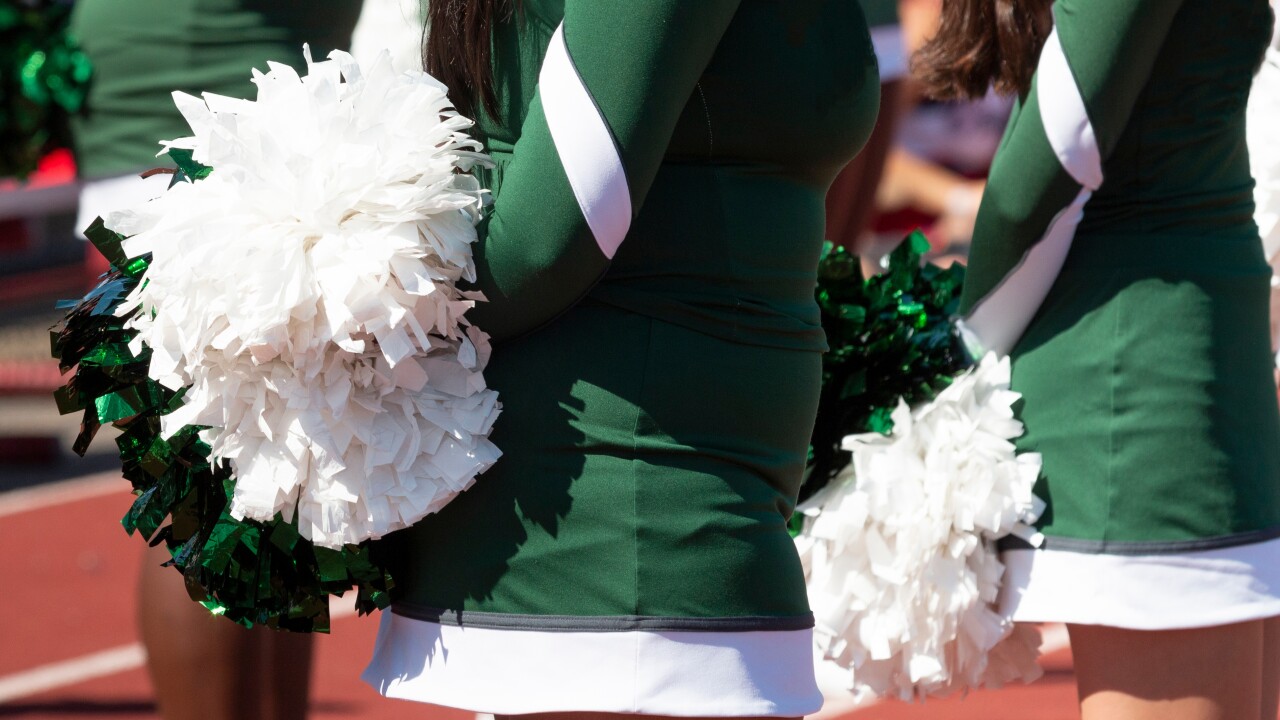 Close,Up,Of,High,School,Cheerleaders,In,Green,Uniforms,Holding