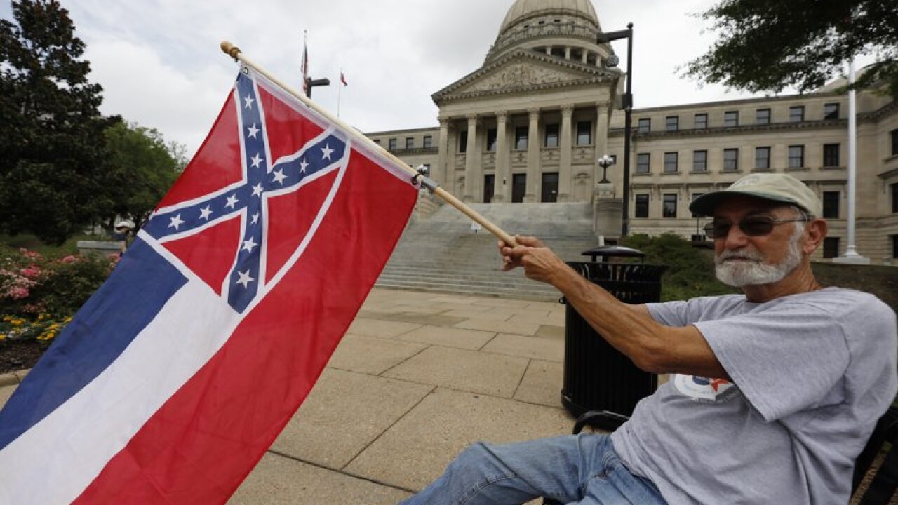 Larry Eubanks of Star waves the current Mississippi state flag as he sits before the front of the Capitol, Saturday, June 27, 2020, in Jackson, Miss. While a supporter of the current flag, Eubanks says he would hope lawmakers would allow a proposed flag change to be decided by the registered voters. The current state flag has in the canton portion of the banner the design of the Civil War-era Confederate battle flag, that has been the center of a long-simmering debate about its removal or replacement. (AP Photo/Rogelio V. Solis)