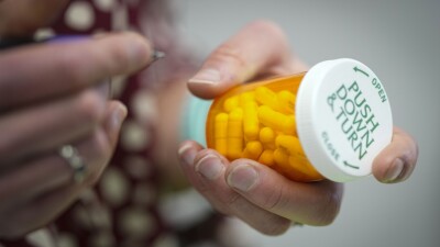 Person holds a prescription pill bottle.
