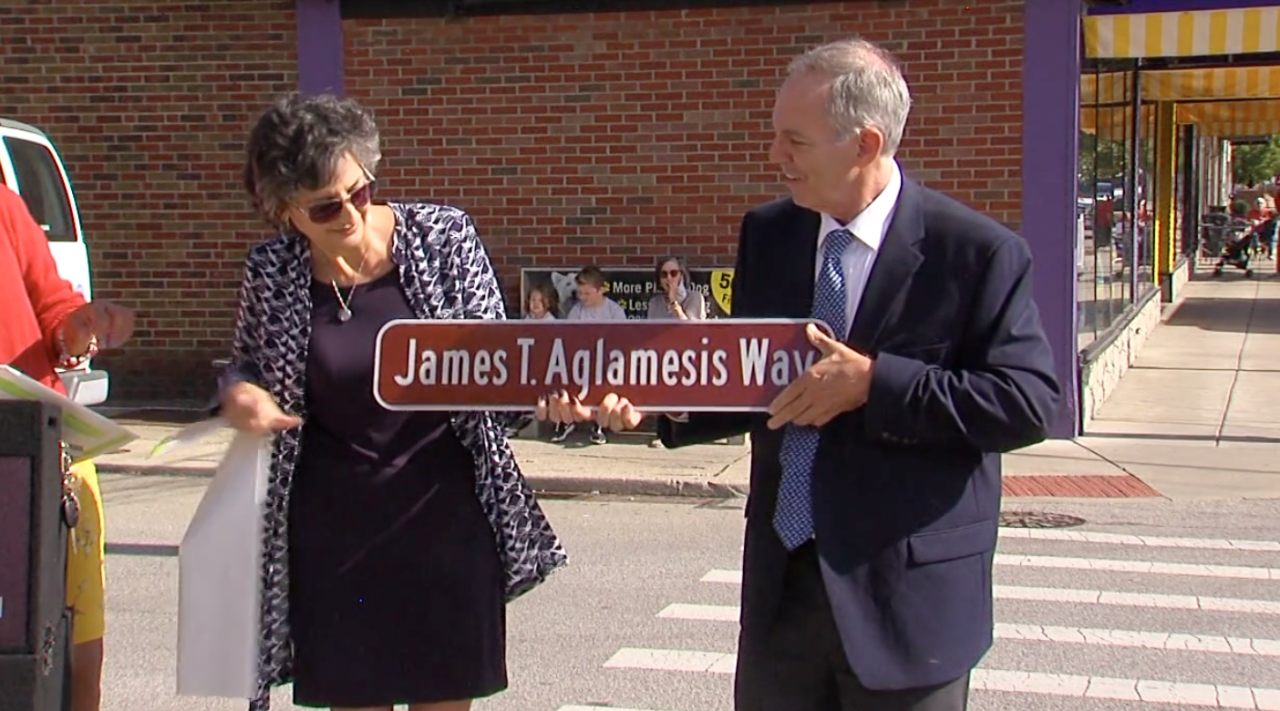 The family of James Aglamesis celebrates his honorary street name outside the family's historic ice cream shop.