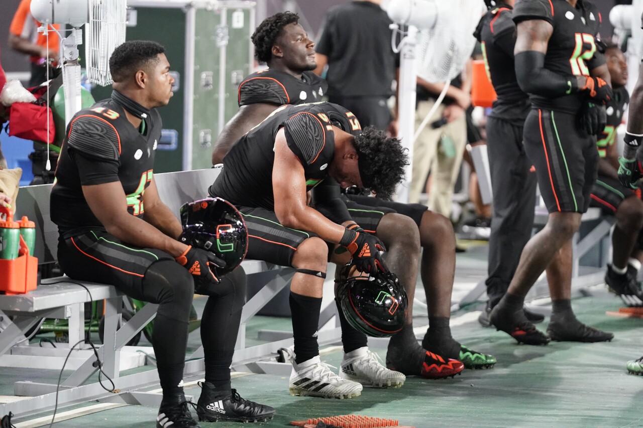 Miami Hurricanes players sit dejected on sideline after giving up game-winning touchdown vs. Georgia Tech Yellow Jackets, Oct. 7, 2023