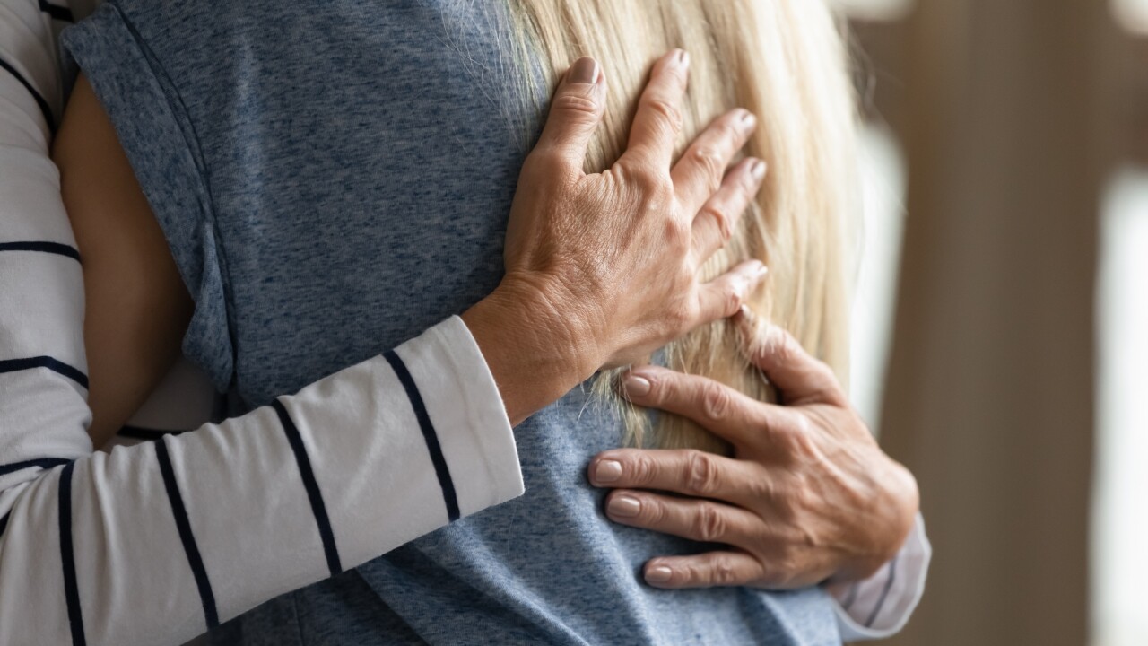 Two people hug.