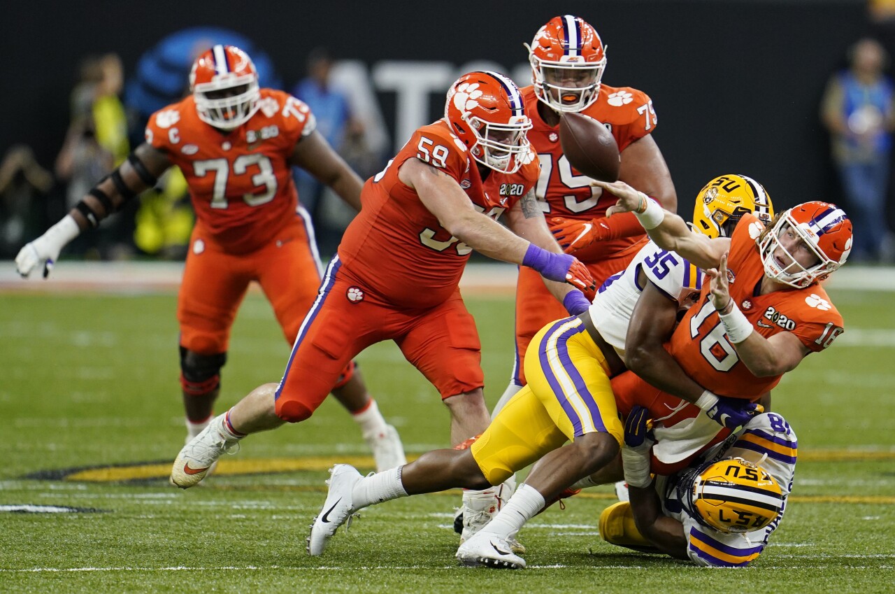 Clemson Tigers QB Trevor Lawrence passes under pressure vs. LSU Tigers in College Football Playoff National Championship