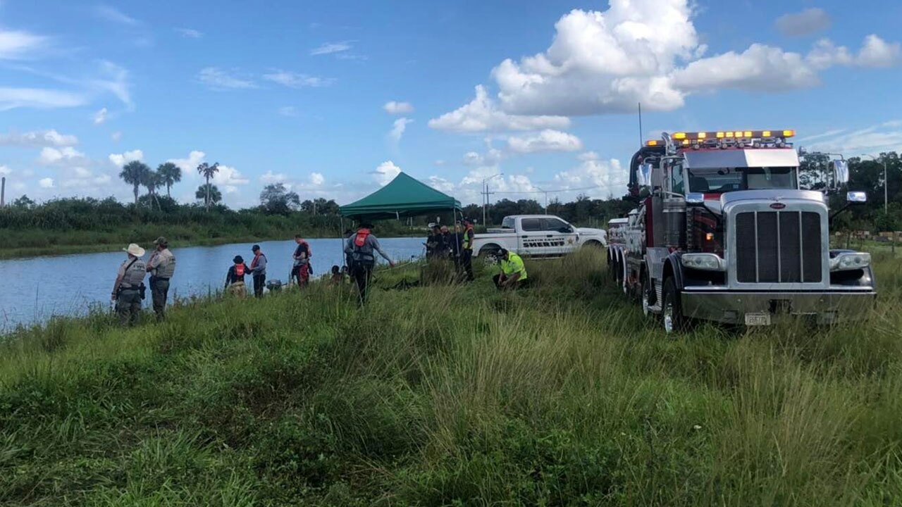 Crews retrieve a car from a pond near Indiantown, Florida, after two bodies were pulled from the waterway on July 25, 2022.