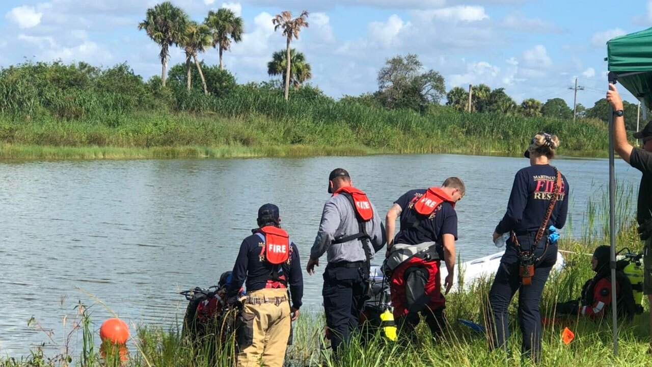 Crews retrieve a car from a pond near Indiantown, Florida, after two bodies were pulled from the waterway on July 25, 2022.