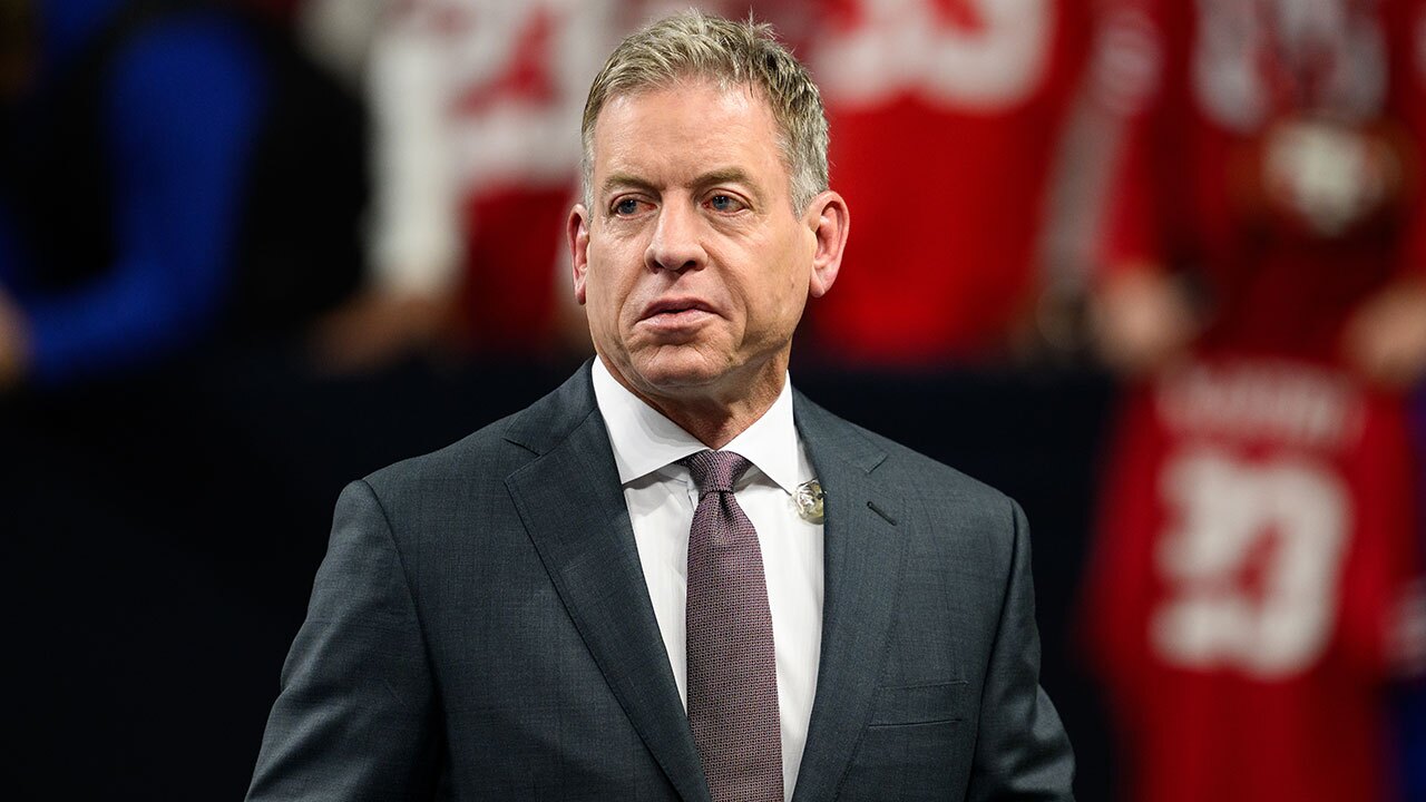 Troy Aikman walks on the field before an NFL football game between the Indianapolis Colts and San Francisco 49ers, Monday, Dec. 22, 2025, in Indianapolis.