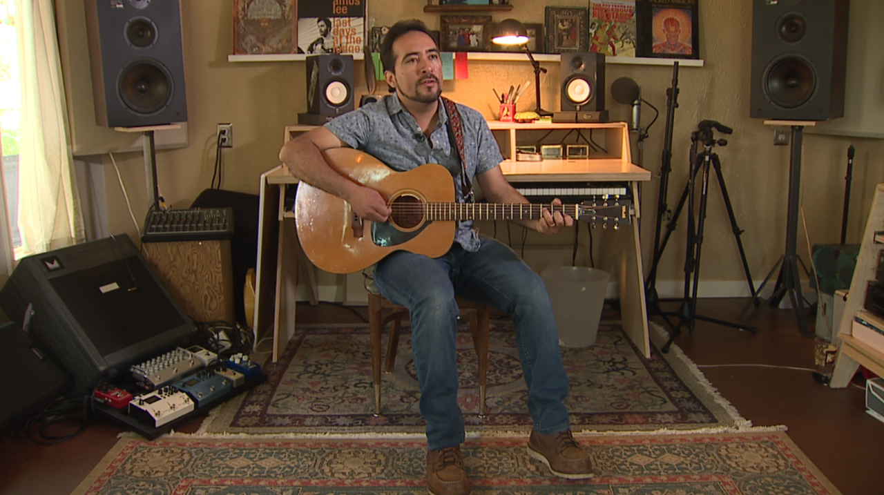Antonio Lopez plays guitar in his home