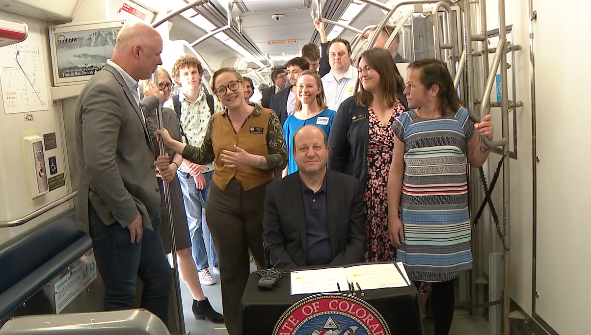 governor polis signs bill on train.png