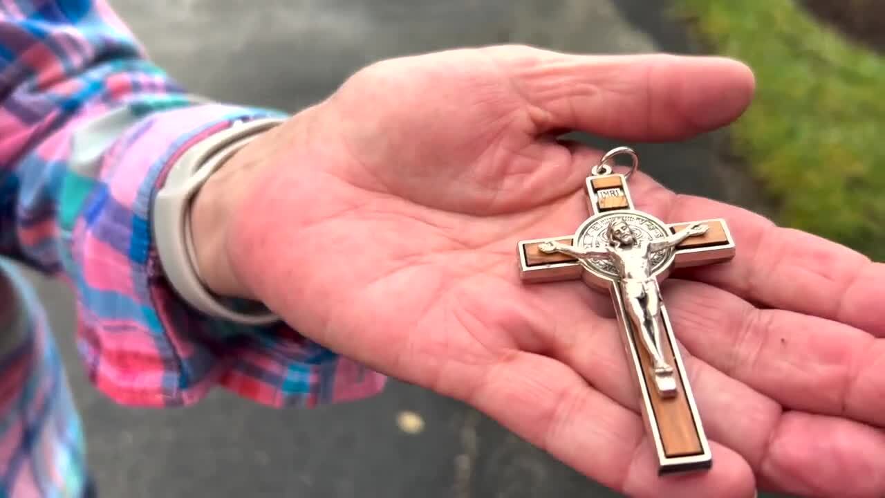 Sylvia Macmenomay holds cross she received from her pastor as she hid in her closet, March 3, 2024