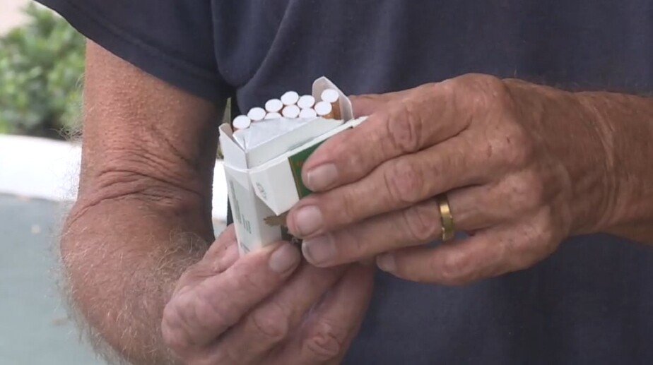 Tom Thompson of Deerfield Beach opens a pack of cigarettes on July 9, 2021.jpg