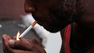 A man lights a cigarette.