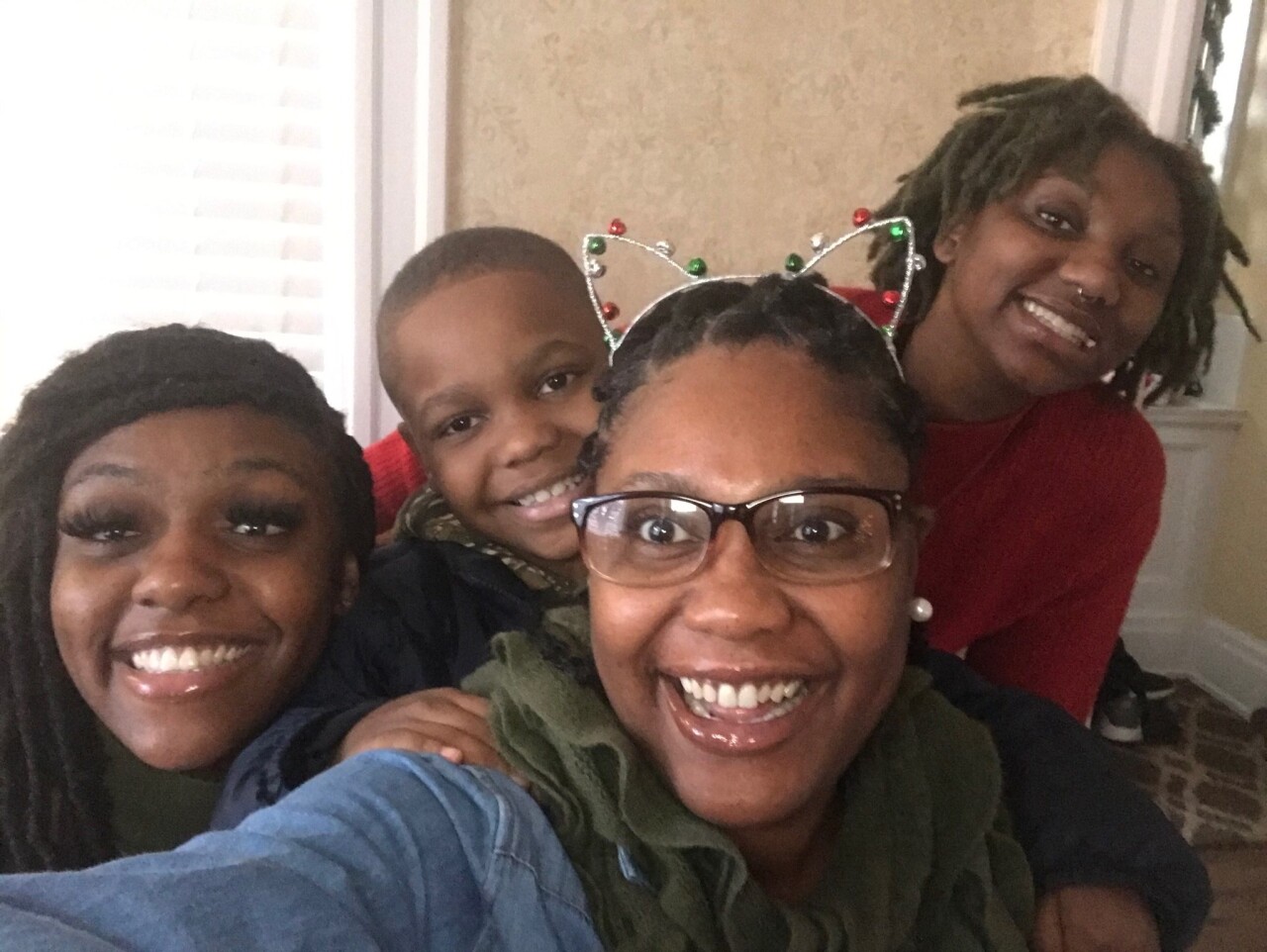 LaTasha Hambrick, second from right, smiles in this selfie with her son and two daughters. Hambrick is wearing glasses and a cat ear hairband.