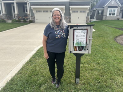 Lana Clark stands next to her free little library in North Ridge Pointe