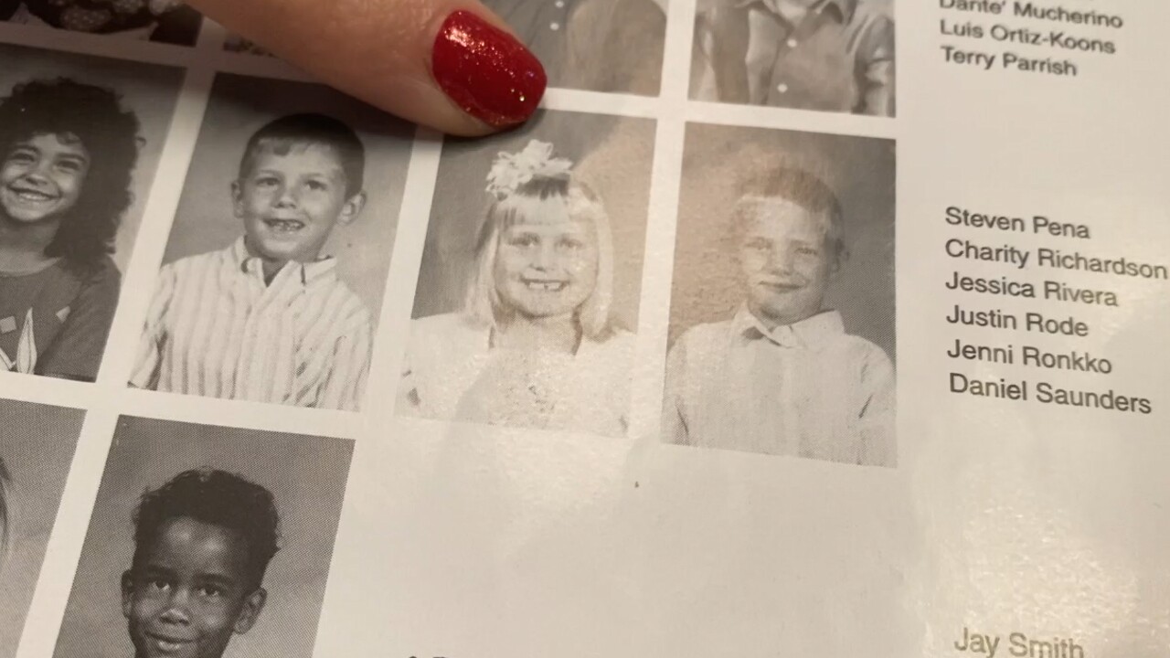 Principal Jenni Ellis looks at her old yearbook from Everglades Elementary School in Okeechobee County on April 27, 2022.jpg