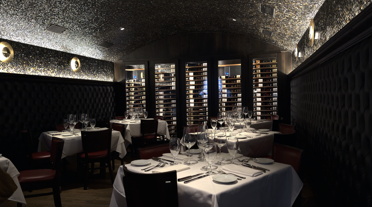 Dining area with a wine selection on the wall.