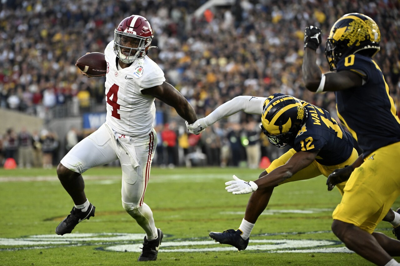 Alabama Crimson Tide QB Jalen Milroe eludes Michigan Wolverines cornerback Josh Wallace in second half of Rose Bowl, Jan. 1, 2023