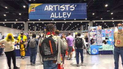 People walk up to a booth at Comic-Con.
