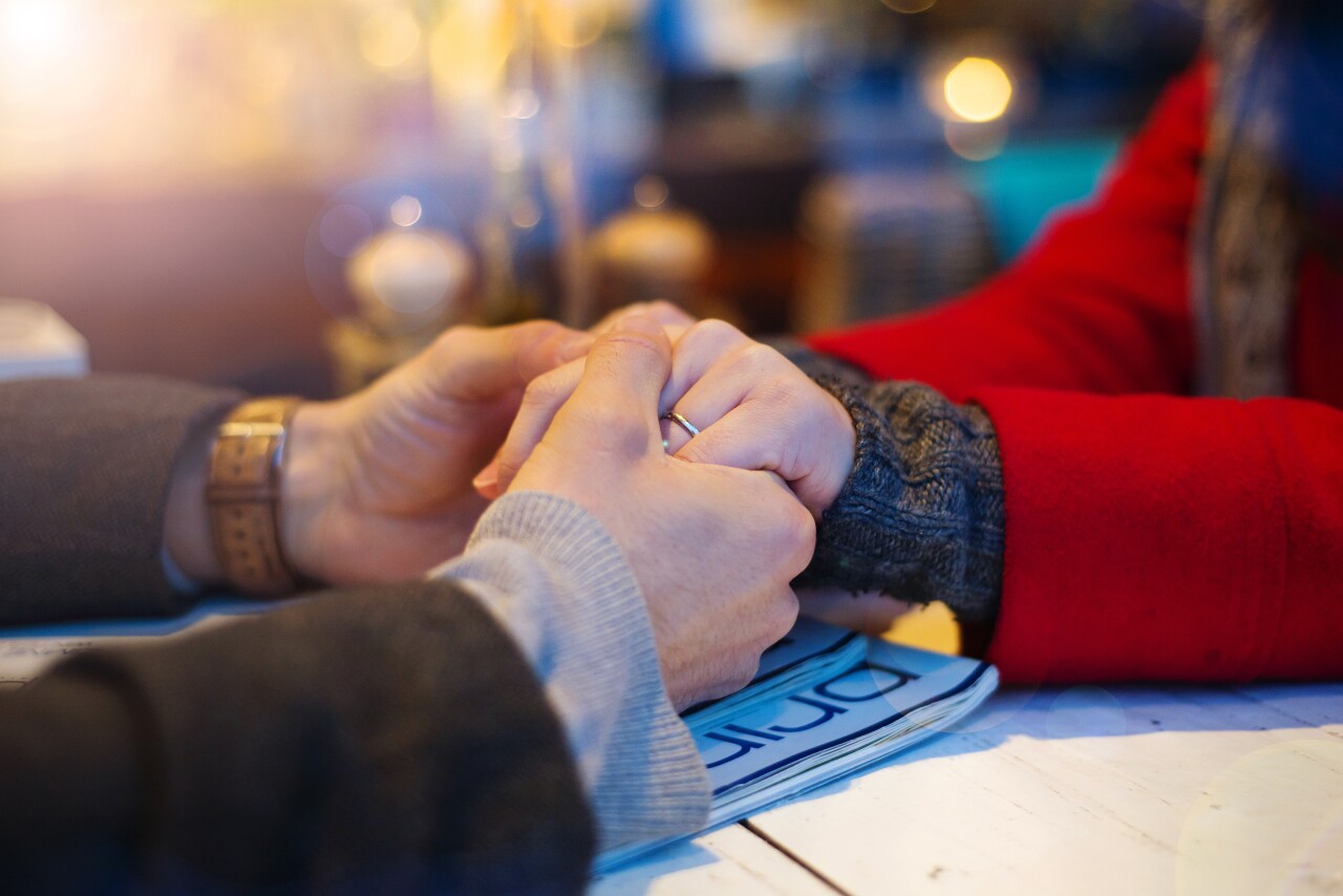 Couple in cafe holding each other's hand