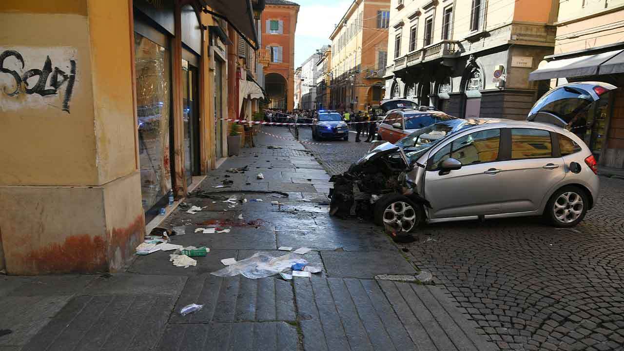 Blood is seen next to a destroyed car on a street of Modena, Italy, Saturday, May 16, 2026. 