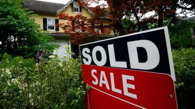 A sale sign stands outside a home in Wyndmoor, Pa.