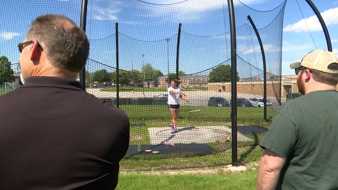 THEA KRAL'S COACHES WATCH HER THROW.jpg