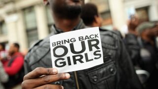 A man holds a sign reading "bring back our girls"