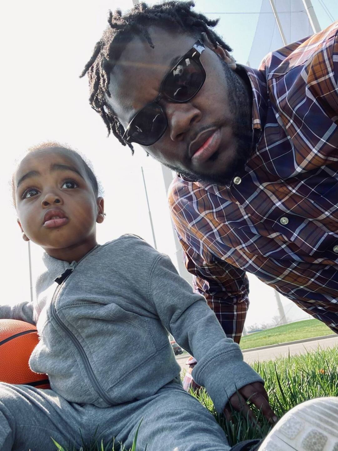 This photo shows Rodney Walker and his young son sitting outside next to a basketball.
