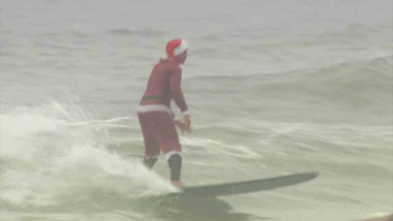 A unique twist on holiday cheer: Around 15,000 people hit the beach on Christmas Eve morning to watch the Surfing Santas in Cocoa Beach.