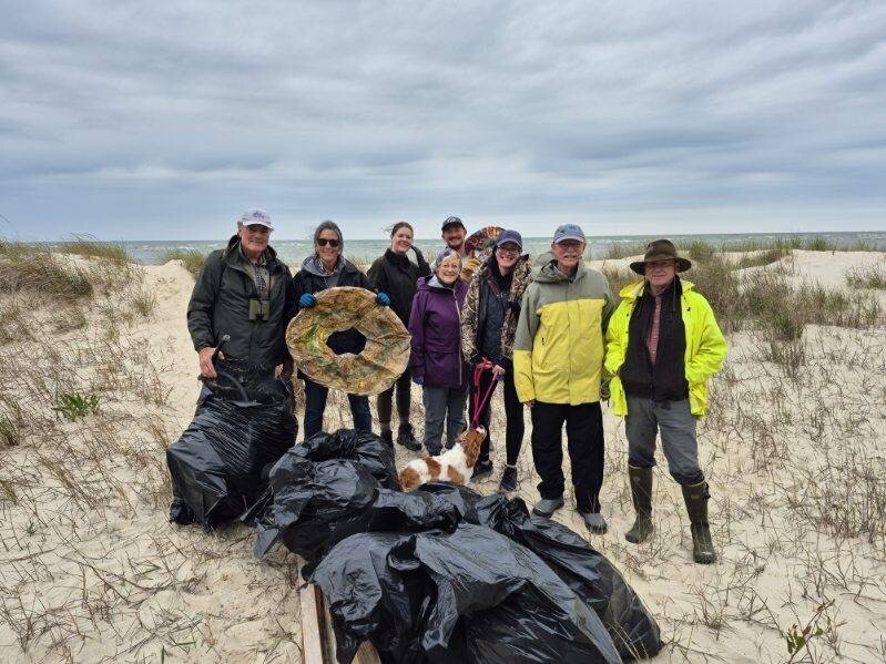 Clean the Bay Day volunteers with the Virginia Eastern Shore Land Trust pose with an inner tube after cleaning a beach near Eastville, Virginia. 