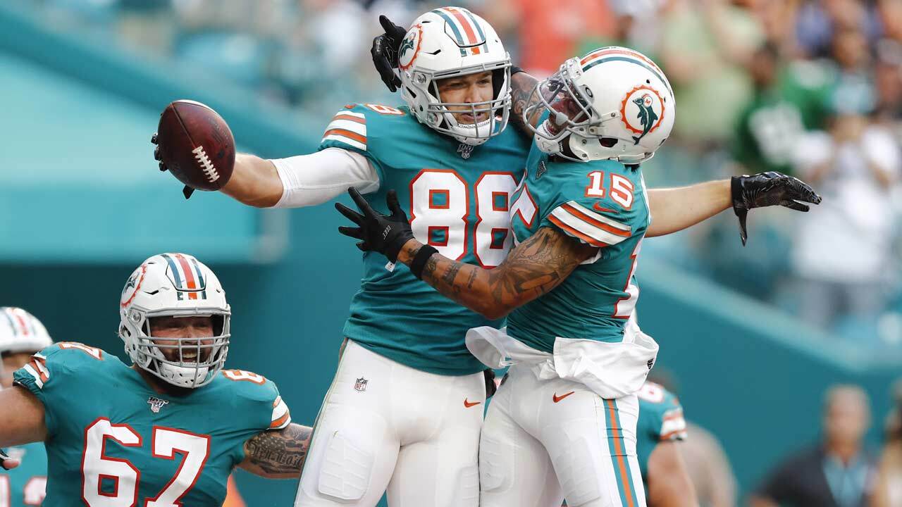 Miami Dolphins wide receiver Albert Wilson (15) congratulates tight end Mike Gesicki (88) after Gesicki scored a touchdown, during the second half at an NFL football game against the Philadelphia Eagles, Sunday, Dec. 1, 2019, in Miami Gardens, Fla. To the left is Miami Dolphins center Daniel Kilgore (67).