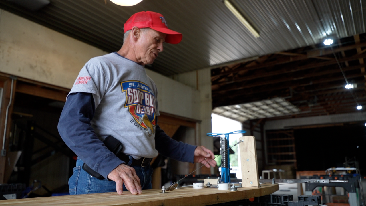 Lee Smith inspecting the chassis of a Soapbox Derby car