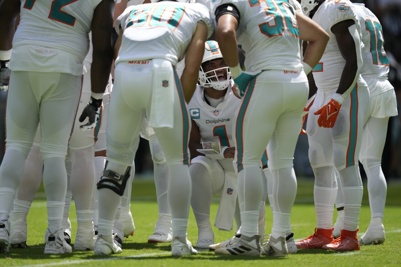 Miami Dolphins QB Tua Tagovailoa crouches on knee in huddle vs. Buffalo Bills, Sept. 25, 2022