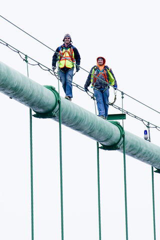 Workers preparing the Mackinac Bridge for winter