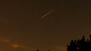FILE - In this long exposure photo, a streak appears in the sky during the annual Perseid meteor shower at the Guadarrama mountains, near Madrid, in the early hours of Aug. 12, 2016.